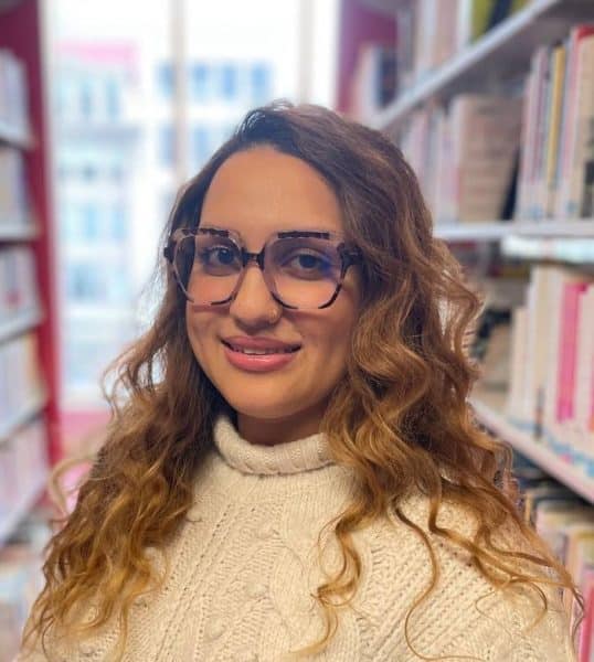 Elnaz Shabani Lux Research Analyst headshot wearing glasses and a sweater.