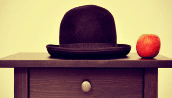 bowler hat and apple on bureau, homage to Rene Magritte painting The Son of Man