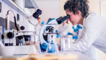 Woman looking into a microscope
