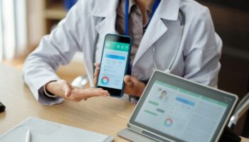 Doctor showing a health app on a phone and tablet