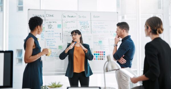 People brainstorming in front of a whiteboard