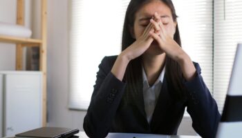 Frustrated office worker sitting at her desk