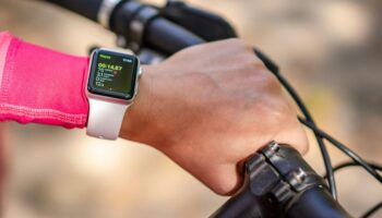 Person riding bike wearing exercise watch