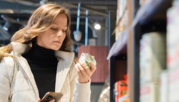 Woman reading the ingredients of a product while shopping