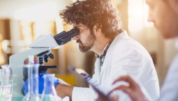 Man looking through microscope in a lab