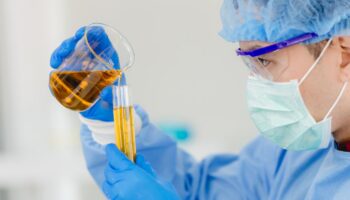 Lab technician pouring liquid into vials
