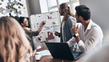 Group of office workers brainstorming around a whiteboard